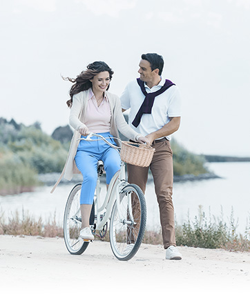 Hombre enseñándole a montar bicicleta a su pareja