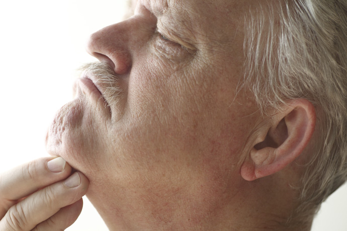 Hombre se toca bulto bajo la mandíbula