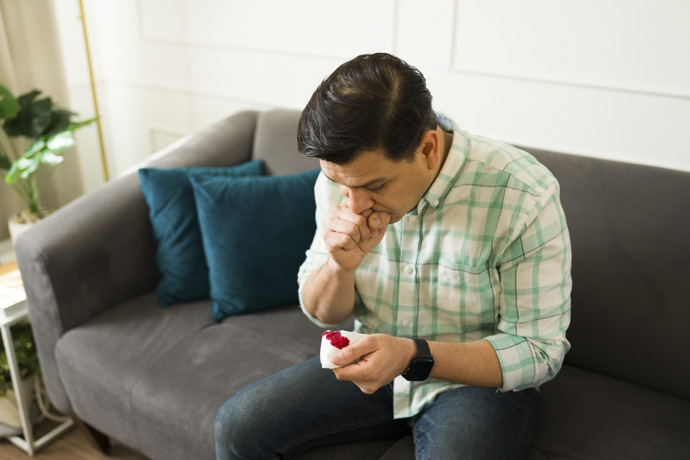 Hombre preocupado por escupir mucosa con sangre