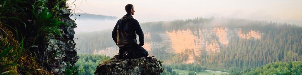 Hombre meditando en las montañas