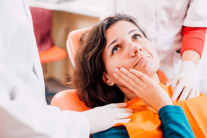 Imagen de mujer en el dentista porque no sabe qué es bueno para el dolor de muelas. 