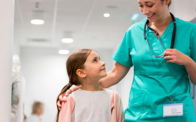 Niña caminando en el hospital con la doctora