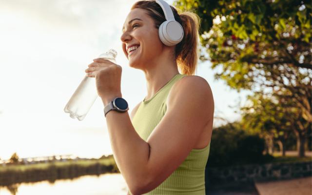 Mujer tomando agua ddurante una caminata