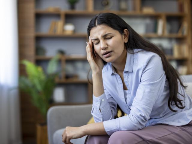 Mujer con dolor de cabeza, uno de los síntomas para los que sirve el ibuprofeno