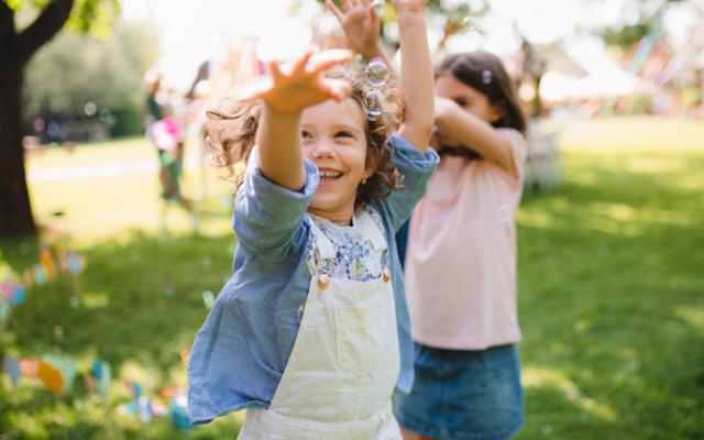 Niñas jugando con burbujas en el parque