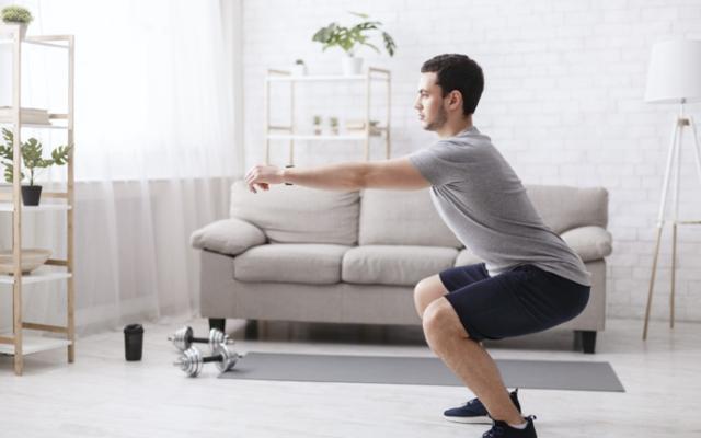 Hombre haciendo sentadillas en casa