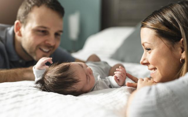 Padres durmiendo a su bebé