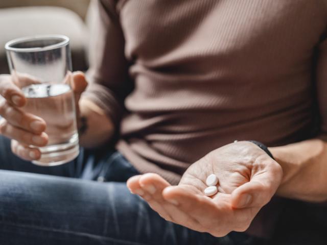Persona tomando pastillas por indicación médica 