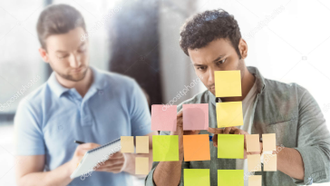 Foto de dos personas pegando post-it.